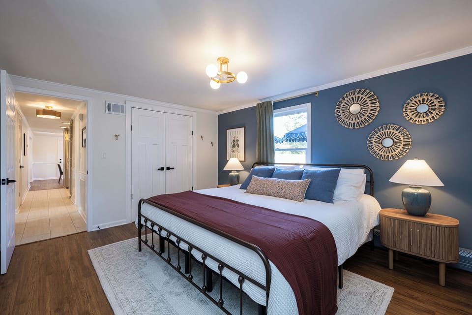 Settle into this serene downstairs bedroom featuring a luxurious king bed, soft lighting, and rich, calming colors. It’s a peaceful retreat designed for comfort, relaxation, and a restful night’s sleep.
