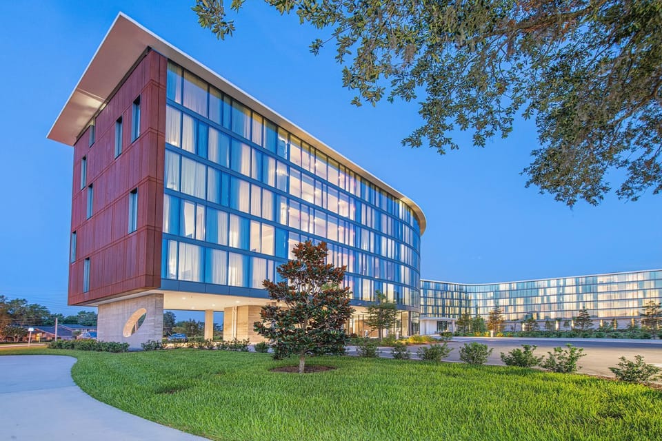 The distinctive facades of Hotel ELEO blend contemporary architecture with organic elements, showcasing a stunning contrast against the twilight sky.
