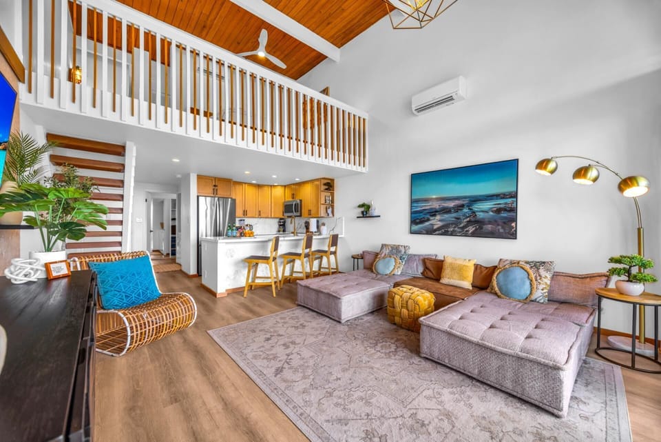 This angle highlights the soaring ceilings and loft railing, giving the main living space a breezy, spacious feel.