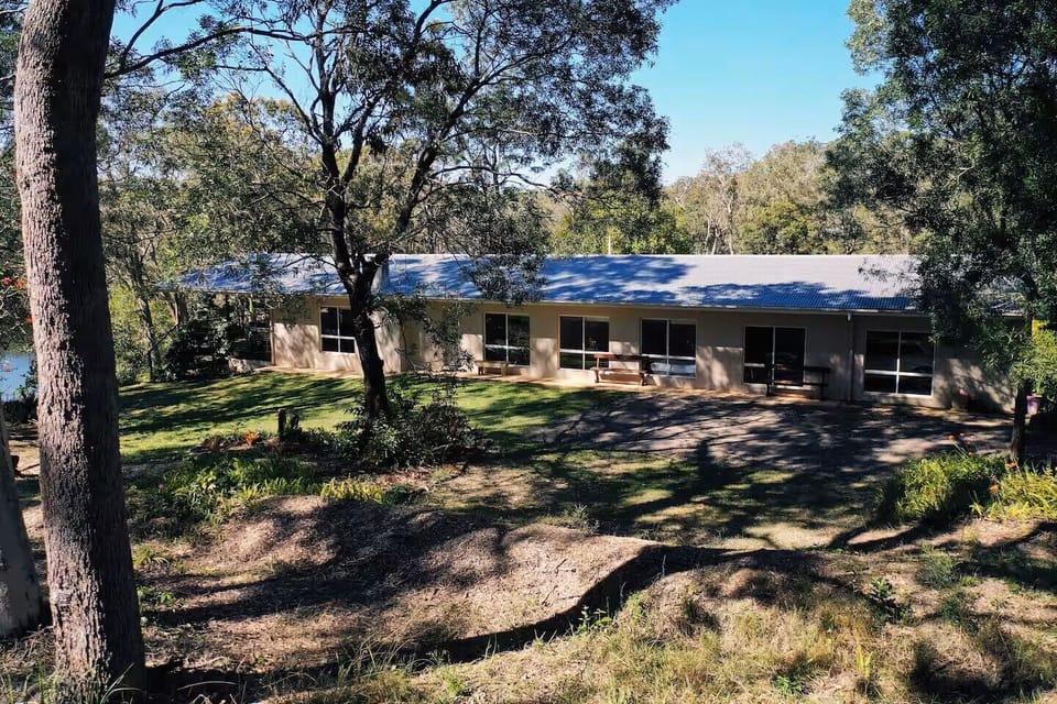 Very large open plan living area opening onto under-roof deck overlooking river