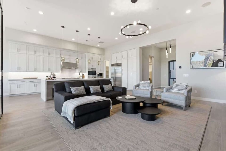Living room offers a warm and modern atmosphere with a sleek fireplace, cozy seating, and expansive glass doors that open to the patio.