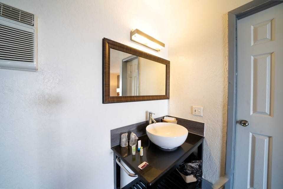 Freshen up at the modern vessel sink with bright mirror light.