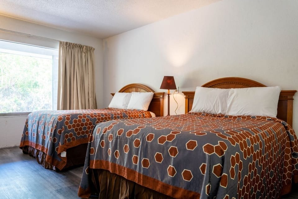Relax with a bright window view beside twin beds.