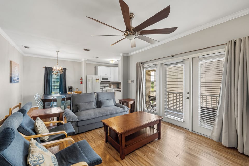 Relax in your bright, open-concept living space on the second floor with cozy furnishings, modern kitchen, and private balcony access for the perfect home-away-from-home experience.