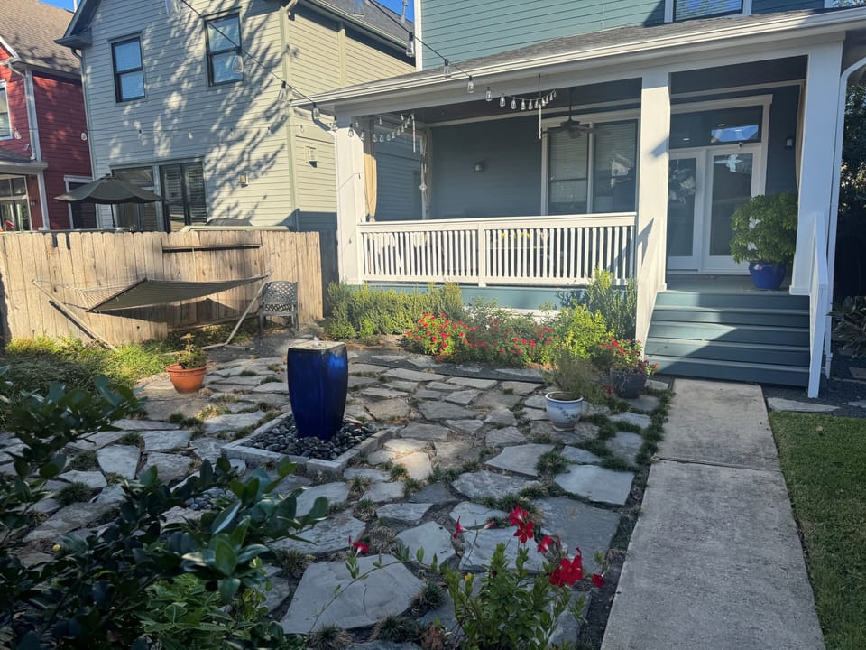 Covered back porch with ceiling fan and lighted flagstone patio with fountain
