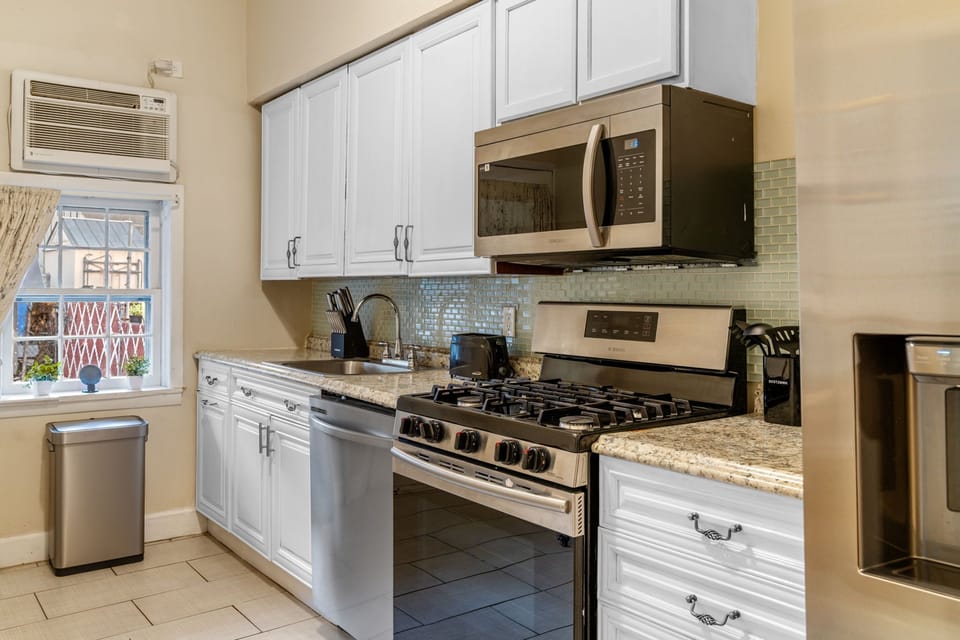 Modern gas stove, microwave, dishwasher, and a complete set of cookware and utensils make meal prep simple and efficient.