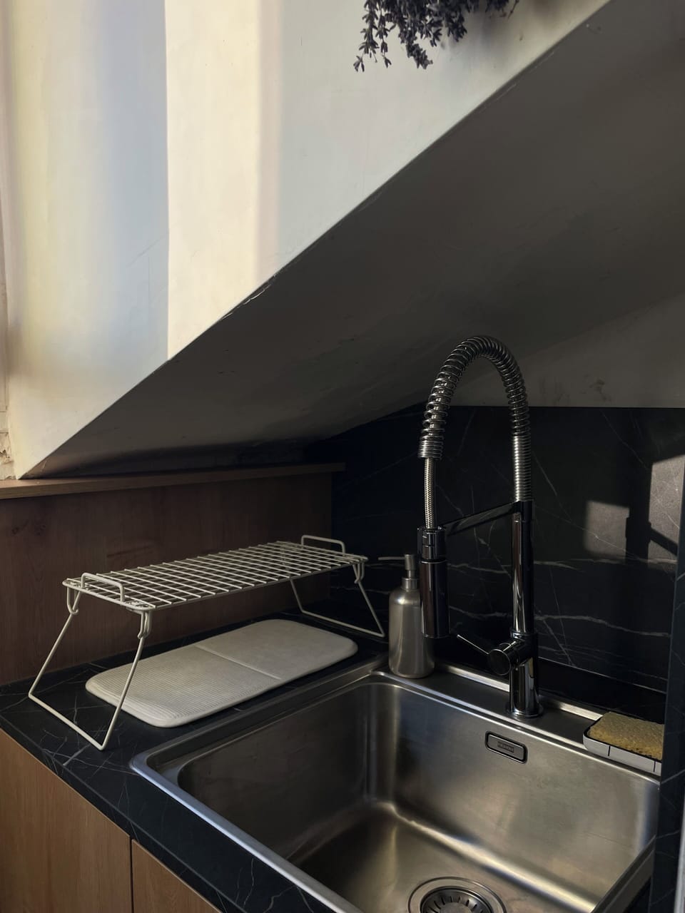 Compact kitchen with stainless steel sink and clean, functional finishes.