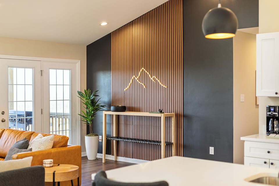 Our stunning open-concept main floor features a custom wood slat accent wall, modern design, and large windows framing sweeping valley views. Step onto the deck and immerse yourself in the beauty of the Shenandoah Valley.