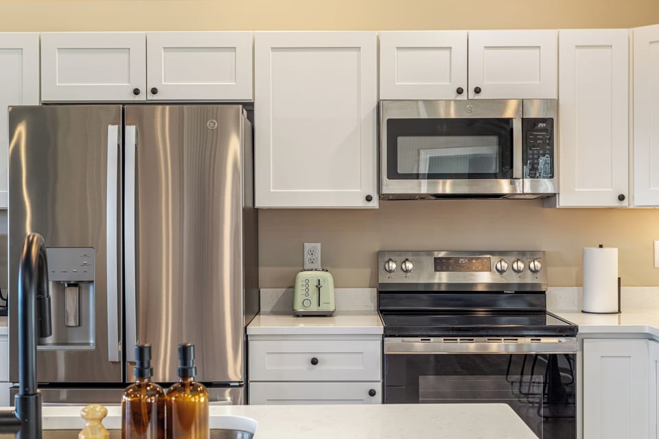 Modern kitchen & dining area perfect for family meals. Fully stocked with cookware, dishes, utensils & appliances. Includes dishwasher pods, dish soap, fresh sponge, paper towels & spices. Everything you need to cook comfortably!