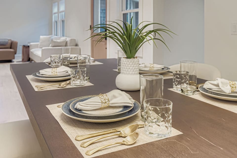 Dine in style at this elegantly set table, perfect for memorable meals with family and friends. The adjacent living area and kitchen offer a seamless open-concept experience.