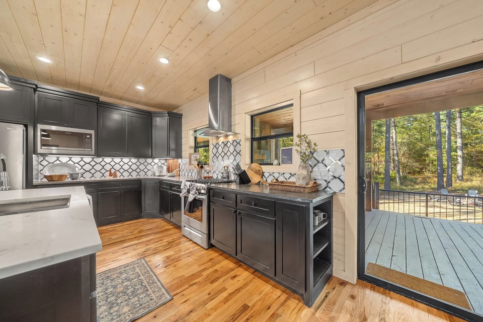 Chef inspired kitchen with gas range, generous counter space, and a convenient walkout to the outdoor grill and deck.