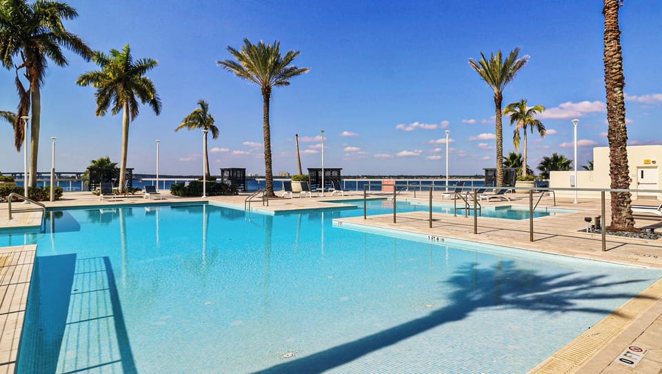 Relax by the waterfront pool! Palm trees & sunny vacation vibes.