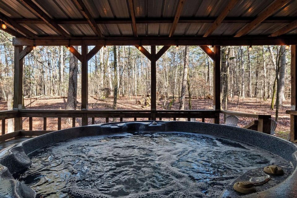 Hot Tub overlooks the fire pit and forest.