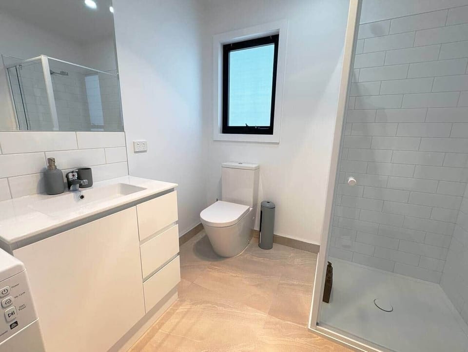 Bathroom with toilet and shower, hair dryer, tissue, cotton pads, cotton tips, shampoo, conditioner,