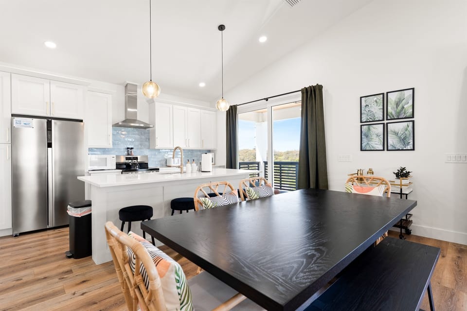 Bright dining and living area with large windows, comfortable seating, and seamless access to the balcony.