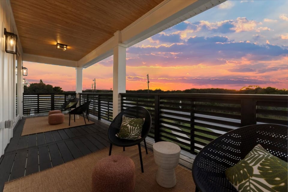 Covered balcony with comfortable seating and expansive sunset views overlooking the surrounding landscape.