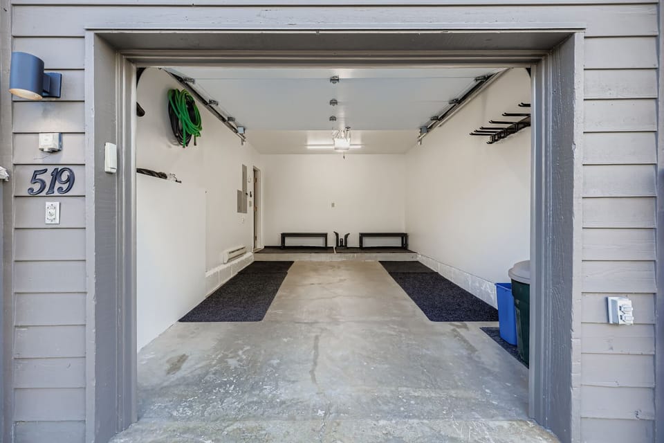 Organized one car attached garage large enough for mid size SUV. Additional parking for a larger vehicle on parking pad outside of garage.