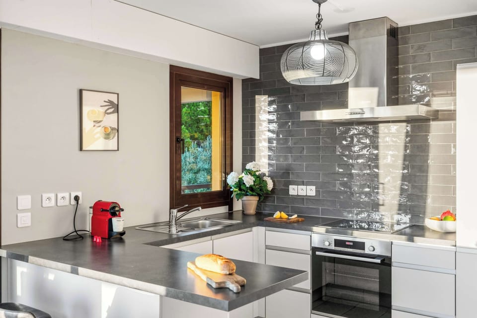 Fully equipped kitchen with stainless steel appliances, Nespresso machine, and dining bar — perfect for cooking, coffee, or casual meals at home.