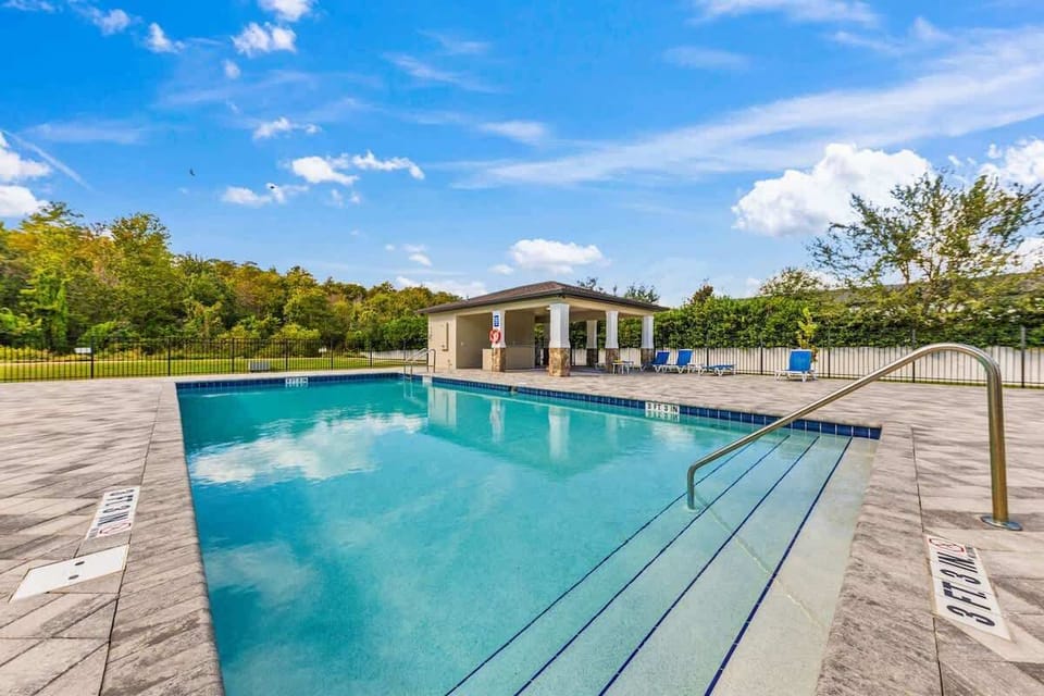 Sparkling community pool with shaded seating area.