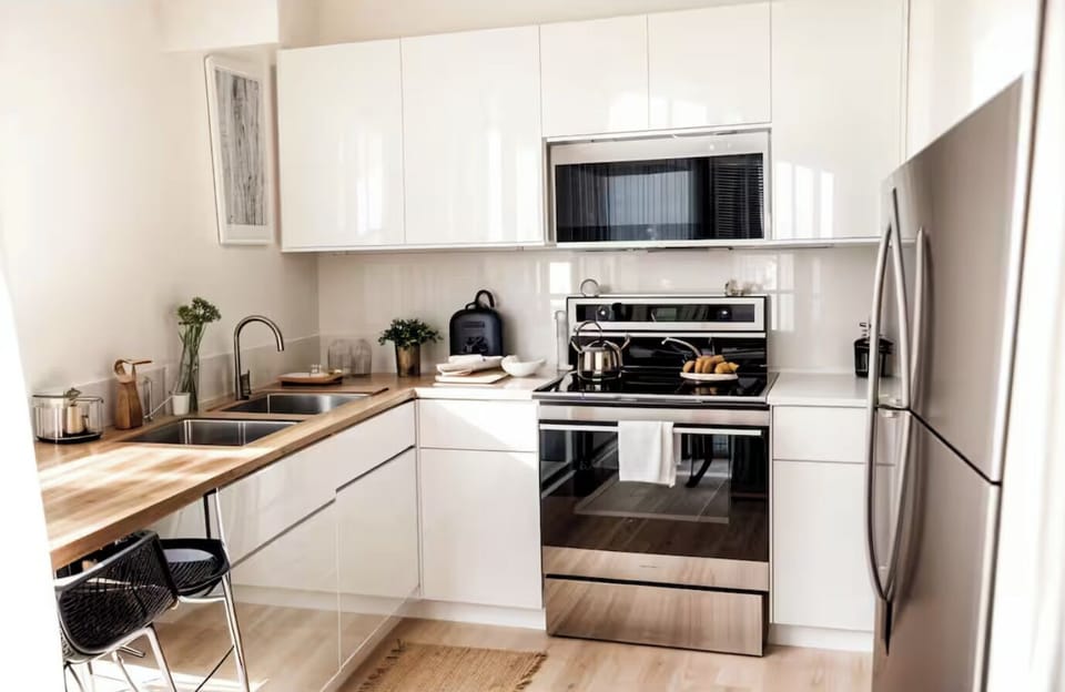 Large fully stocked kitchen with dishes, silverware, cooking ware.