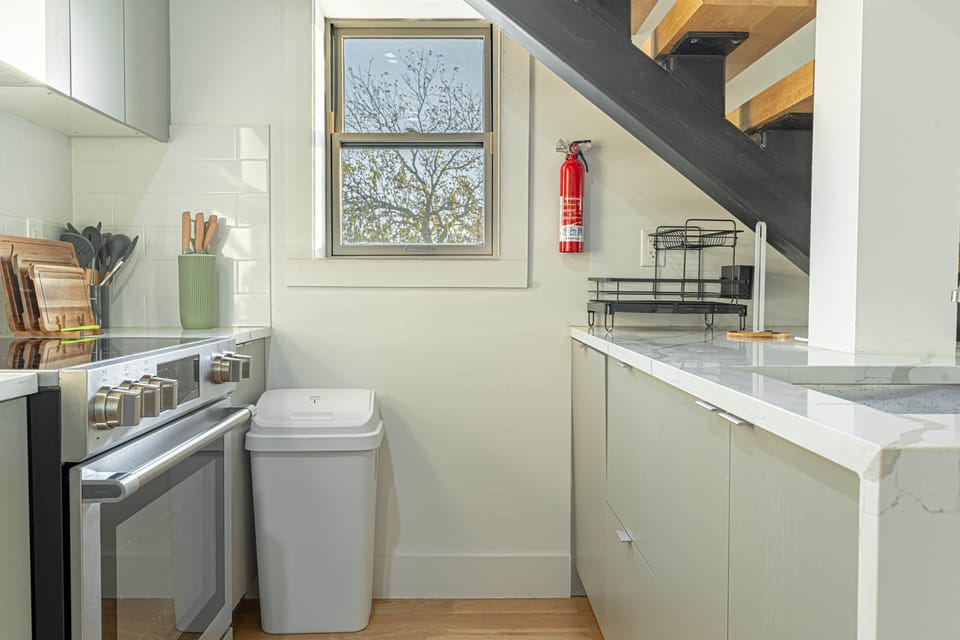 Fully stocked modern kitchen with stainless appliances, ample counter space and window light.