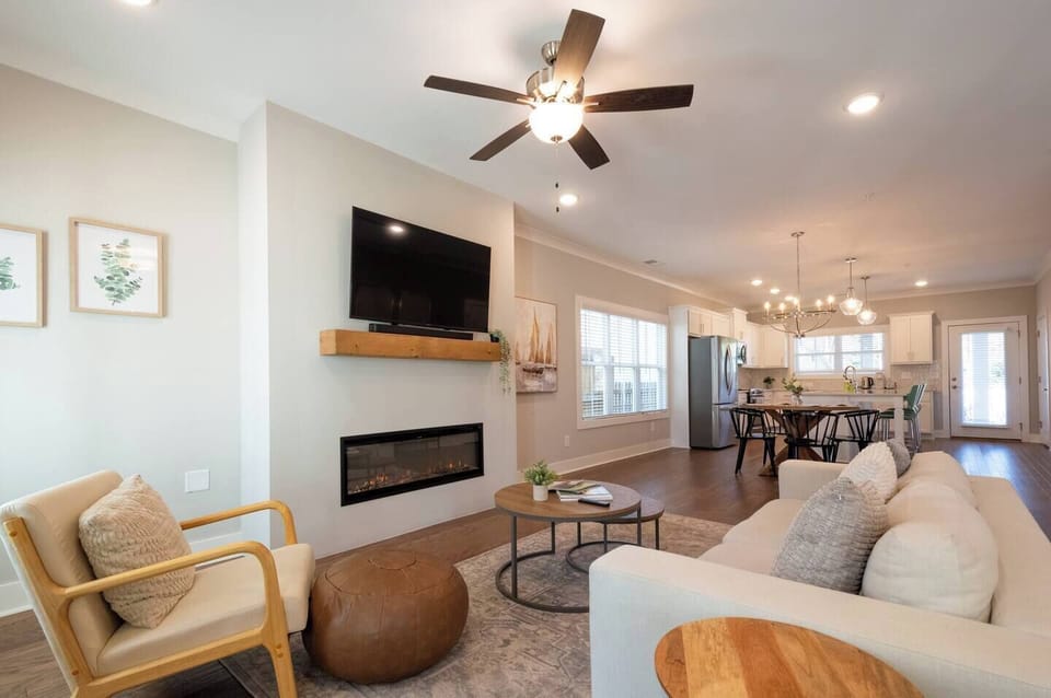 Modern, newly built 3-bedroom home just 1 mile from Marietta Square — Bright, open-concept living area with plush seating, smart 4K TV, and an inviting electric fireplace, total comfort from the moment you arrive.