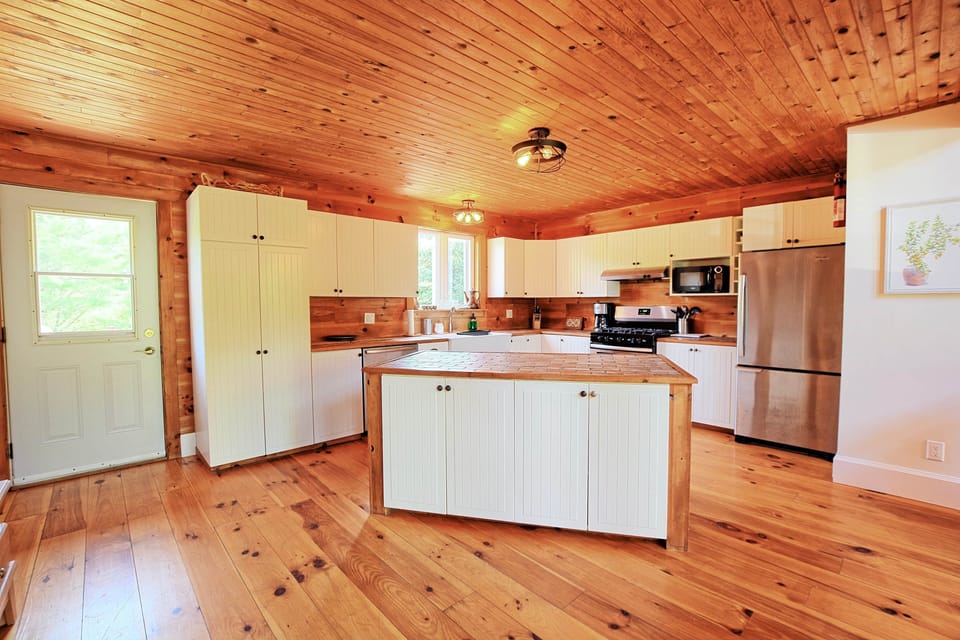 Kitchen with island, and door opening to the back deck and yard