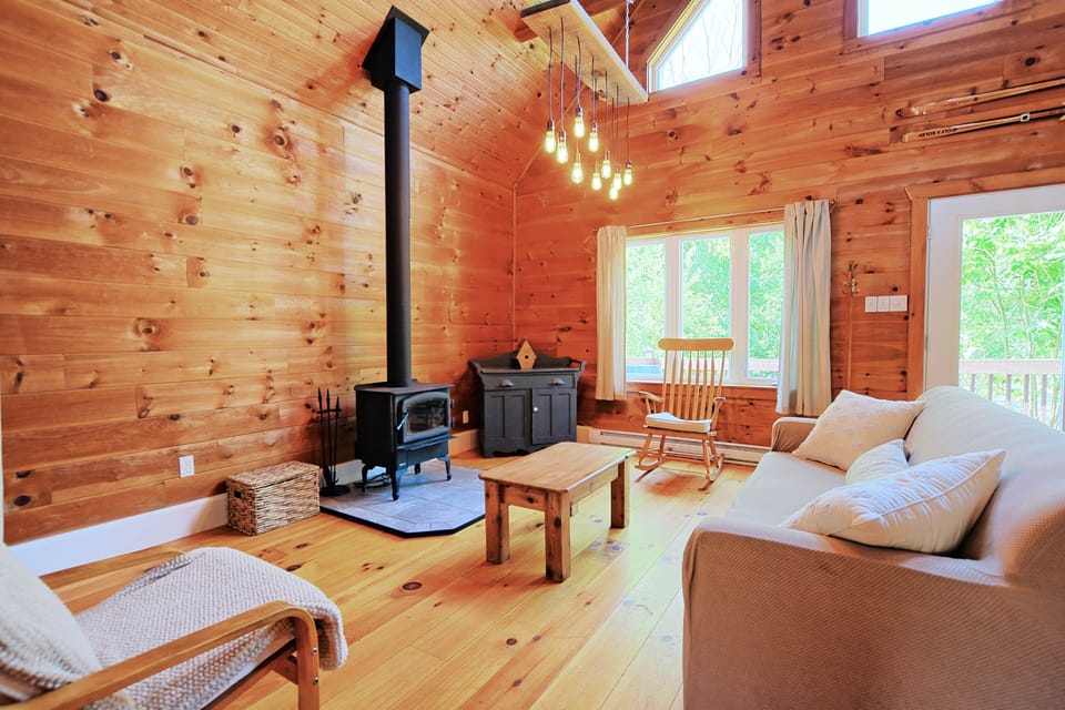 Cozy main living space with wood stove and plenty of natural light