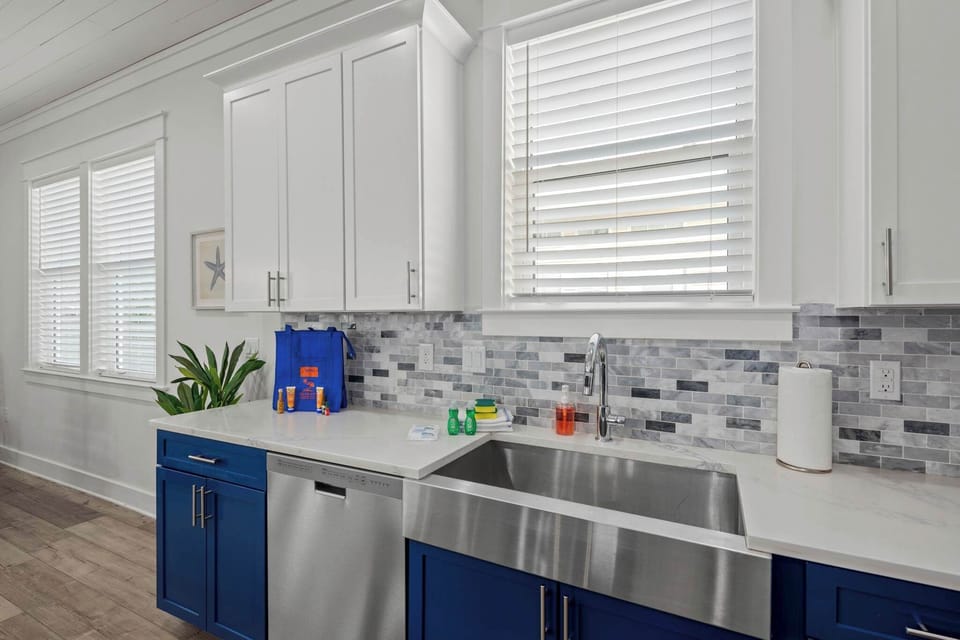 Sleek quartz countertops meet vibrant navy cabinetry for a bold, coastal look. 