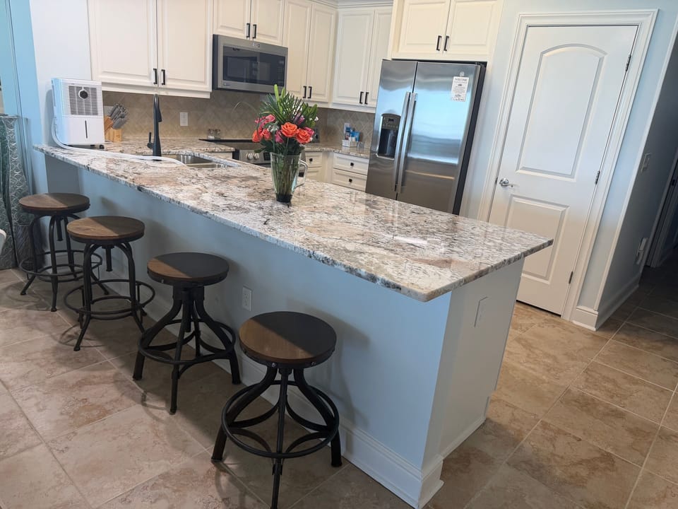 Spacious kitchen with granite countertops, stainless appliances, and bar seating—perfect for coffee mornings or family meals together.