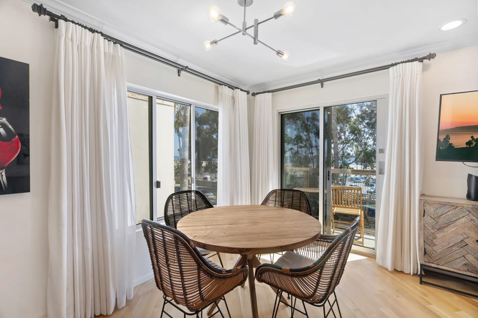 Enjoy a meal at the rattan dining set with a Pacific backdrop.