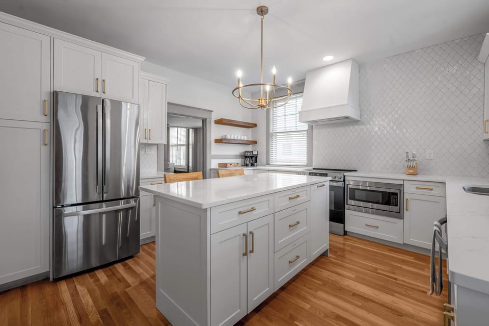 Thoughtfully designed kitchen featuring a spacious island, quartz counters, and premium appliances, perfect for effortless cooking and gathering.