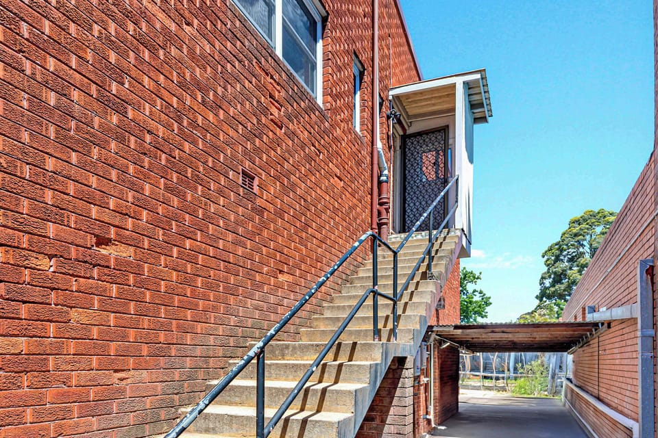 Exterior brick stair access at rear of building.