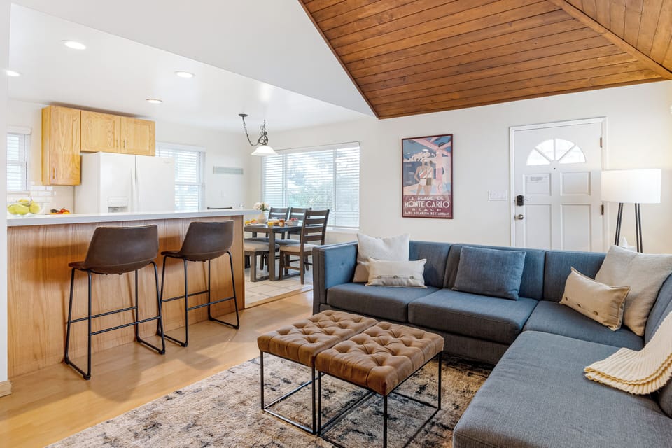 Open-concept layout with a spacious sectional, dining area, and fully equipped kitchen.