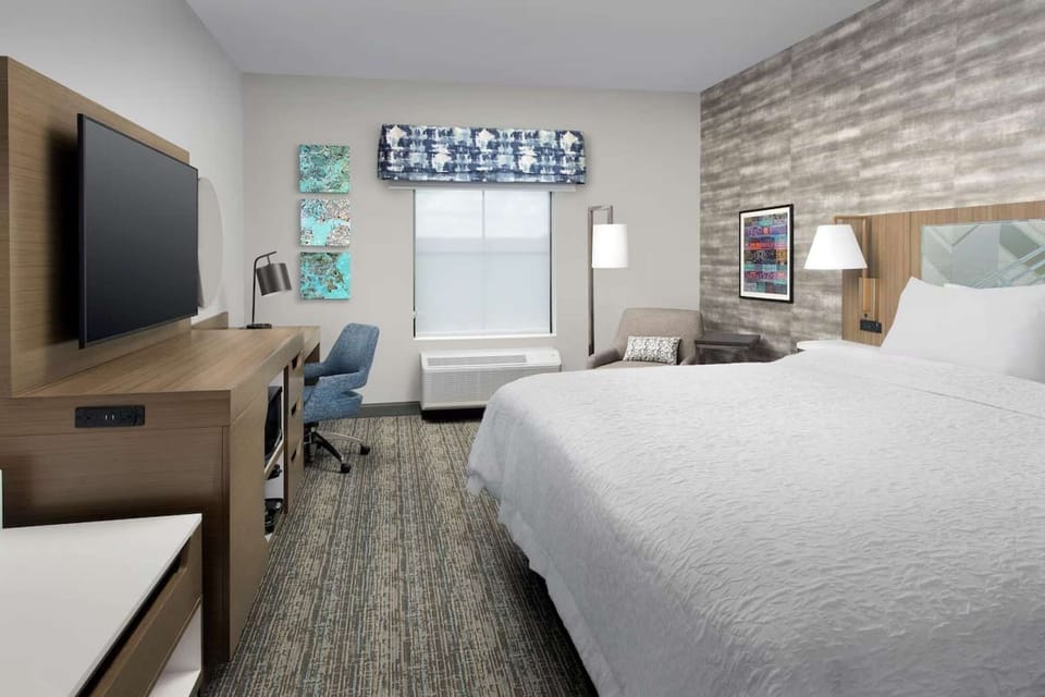Cozy guest room with king bed, desk, and seating area