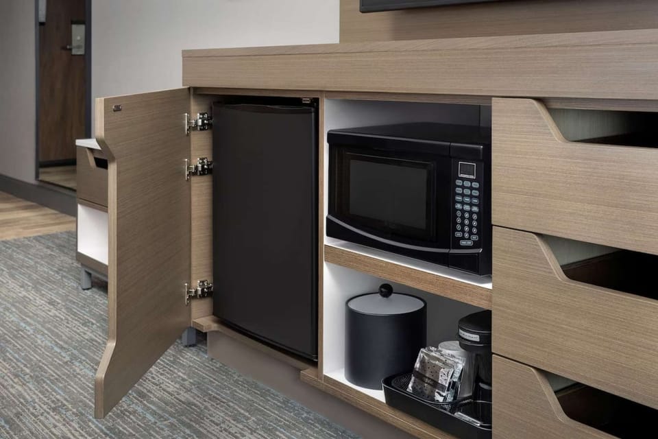 Mini fridge and microwave with coffee setup inside the room