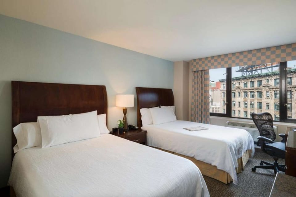 Two-bed room with soft lighting and large window view