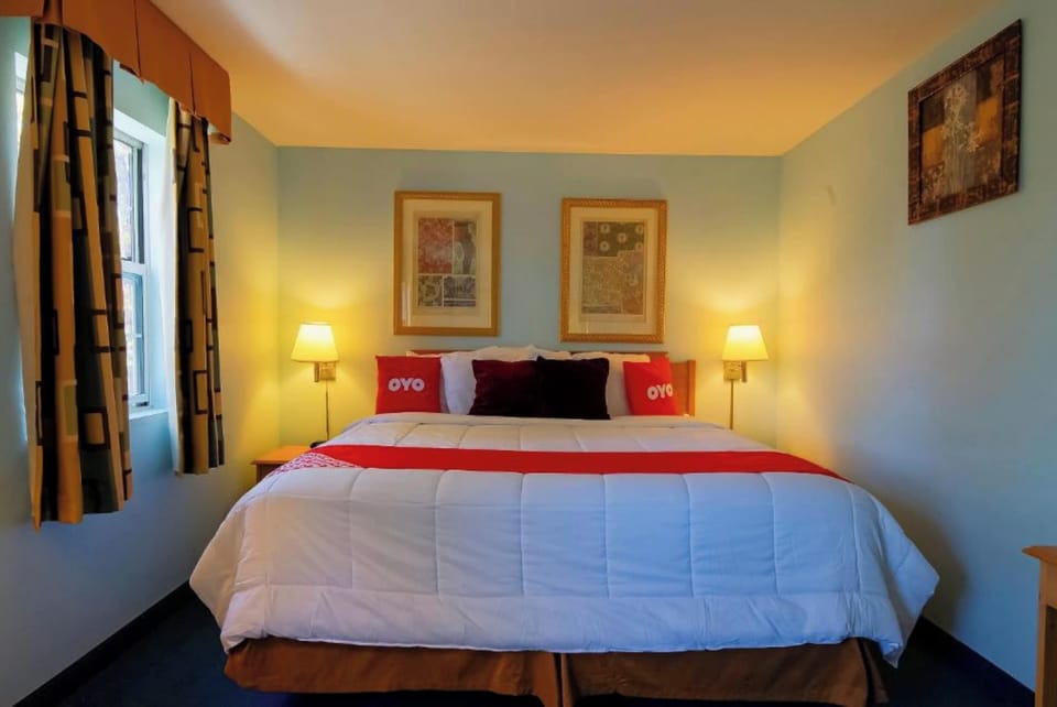 Unwind in a cozy king bed with soft glow.