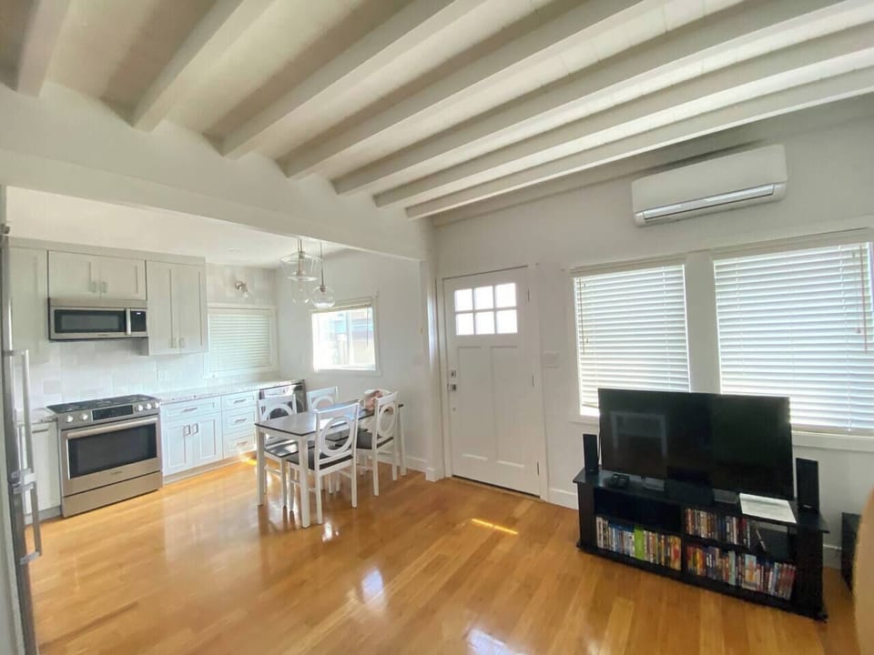 Cozy living and dining area with exposed beams and a smart TV.