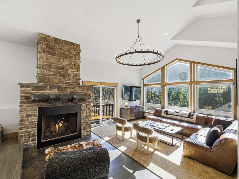 Cozy Up: Relax by the grand stone fireplace in this sun-drenched living area.