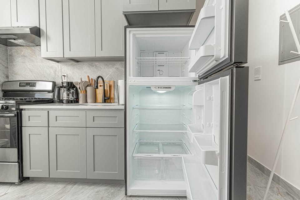 Kitchen with stove, coffee maker, knife sets and open fridge