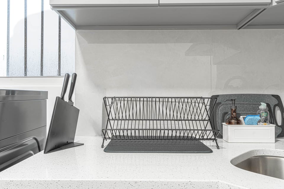 Organized kitchen essentials with drying rack, knives, and cleaning setup