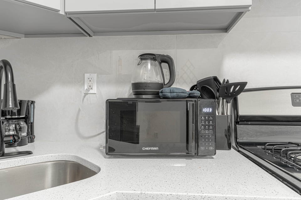Essential kitchen setup with microwave, coffee maker, and sleek appliances