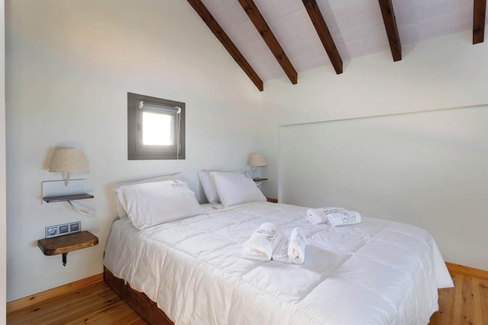 Bright Bedroom with High Wooden Beams and Warm Tones
Elegant sleeping space featuring crisp linens and natural light.
