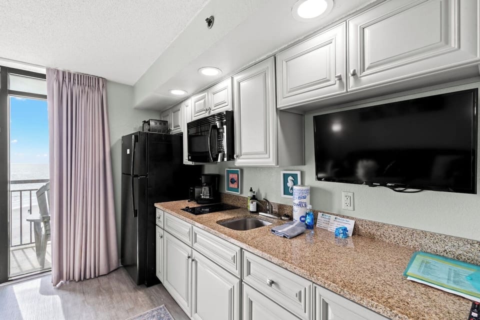 Beach-themed bedroom with two plush queen beds and crisp hotel-style linens. Relax with the Smart TV, free Wi-Fi, and calming coastal décor. A cozy, inviting space perfect for unwinding after a fun day on the North Myrtle Beach shoreline.