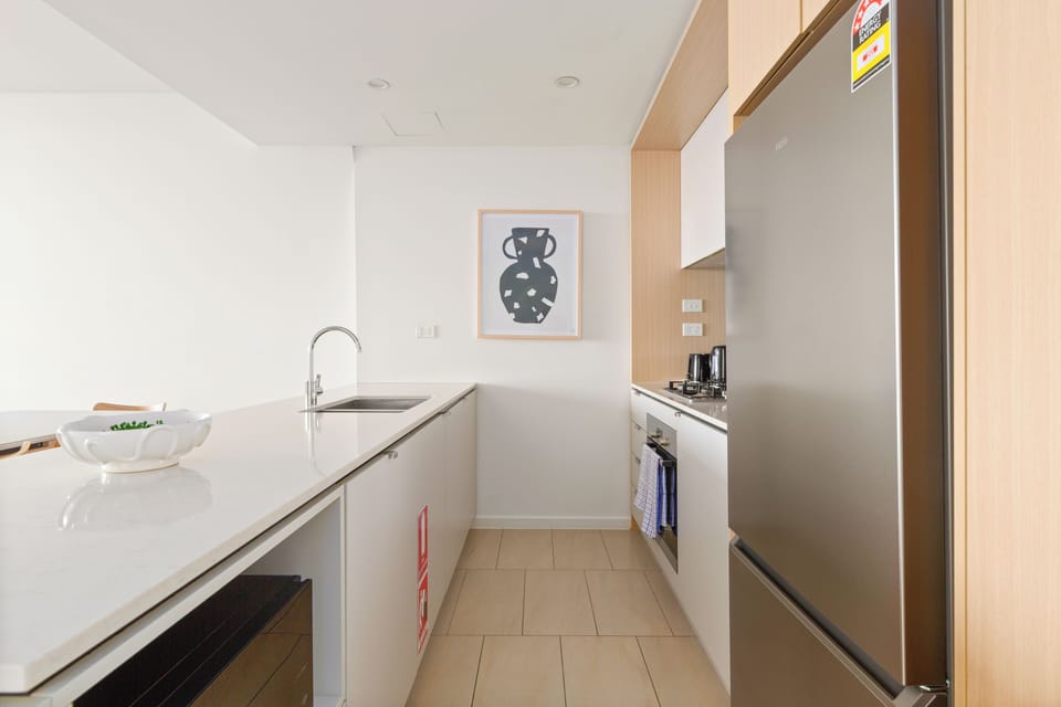 Enjoy cooking in a contemporary kitchen equipped with stone benchtops and premium appliances. 