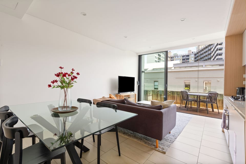 Spacious dining area with a glass-top table, comfortable seating, and plenty of natural light.
