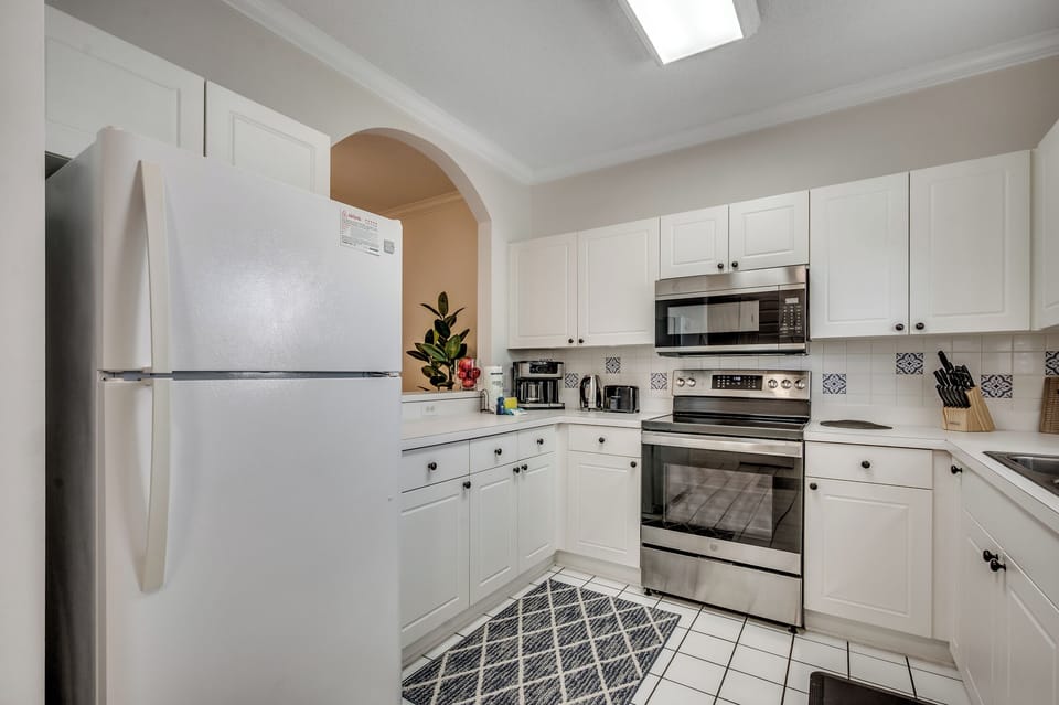 Step into your fully-equipped kitchen with crisp white cabinets and stainless steel appliances