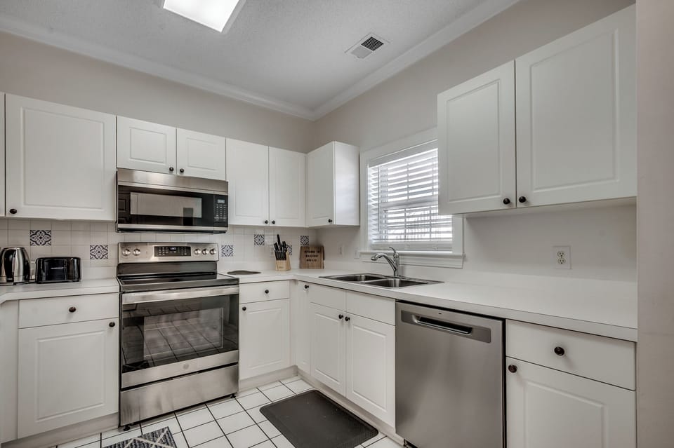 Step into your fully-equipped kitchen with crisp white cabinets and stainless steel appliances