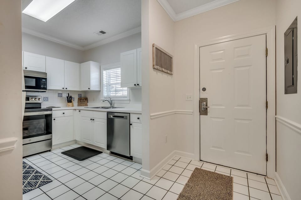Step into your bright, fully-equipped kitchen where you'll love preparing meals with modern appliances and crisp white cabinetry. The spacious layout and natural light create a welcoming space for your culinary adventures.